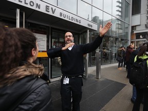 A security guard helps with the evacuation at the EV building after Concordia University in Montreal received a bomb threat targeting Muslim students.