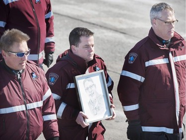 Emergency first responders carry a portrait of RCMP Constable Richer Dubuc ahead of his funeral on the the St-Jean Garrison Military Base in Saint-Jean-sur-Richelieu, Que., on Saturday, March 18, 2017. Constable Dubuc died while on duty on March 6.