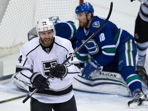 Los Angeles Kings' Dwight King (74) celebrates after scoring a goal as Vancouver Canucks' Ryan Stanton, back right, and goalie Ryan Miller look on during the second period of an NHL hockey game in Vancouver, B.C., on Thursday January 1, 2015.