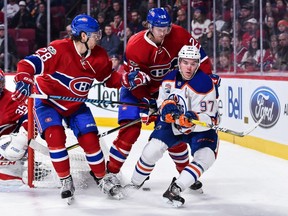 Connor McDavid of the Edmonton Oilers loses the puck as he tries to skate past Nathan Beaulieu (28) and Jeff Petry of the Canadiens during a NHL game at the Bell Centre on Feb. 5, 2017.