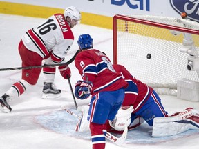 Hurricanes centre Elias Lindholm scores the first goal on Canadiens goalie Carey Price defenceman Jordie Benn looks on during first period Thursday night at the Bell Centre.