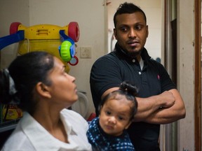 File photo: Supun Thilina Kellapatha (C) and his partner Nadeeka (C) holding their baby boy Dinath, speak as their lawyer Robert Tibbo (R) listens in their flat in Hong Kong on December 13, 2016. The Sri Lankan refugees helped shelter fugitive whistleblower Edward Snowden in 2013.