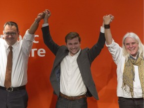 Gabriel Nadeau-Dubois, centre, has his arms raised by Québec Solidaire co-leaders Andrés Fontecilla, left and Manon Massé during an event in Montreal, Sunday, March 26, 2017, announcing him as Québec Solidaire's nominee for the riding of Gouin in a coming by-election.