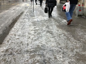 Pedestrians walk on icy sidewalks in downtown Montreal on March 7, 2017.