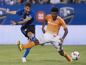 Montreal Impact's Ignacio Piatti, left, takes a shot on goal as Houston Dynamo's Sheanon Williams defends during second half MLS soccer action in Montreal on August 6, 2016.