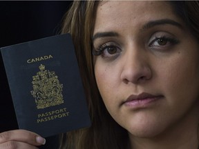 Manpreet Kooner holds up her Canadian passport at her home in Montreal, Monday, March 6, 2017, after being refused entry into the United States.