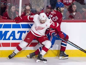 Red Wings' Robbie Russo checks Canadiens' Max Pacioretty along the boards during second period Tuesday night at the Bell Centre.