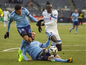 Montreal Impact's Dominic Oduro, right, is tackled by New York City FC's Maxime Chanot, bottom, next to Ronald Matarrita, left, during an MLS Eastern Conference soccer match in New York, Saturday, March 18, 2017.