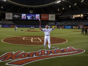 Toronto Blue Jays catcher Russell Martin carries a torch during a ceremony to celebrate the Olympic Stadium's 40th anniversary before the exhibition game between the Toronto Blue Jays and the Boston Red Sox in Montreal on Saturday, April 2, 2016. (Dario Ayala / Montreal Gazette)