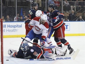 Adam Clendening of the New York Rangers checks Dwight King of the Montreal Canadiens over goalie Henrik Lundqvist of the Rangers as the puck slides toward the goal, but the whistle had called the play dead as the puck broke loose in the first period of an NHL hockey game at Madison Square Garden on March 4, 2017, in New York.