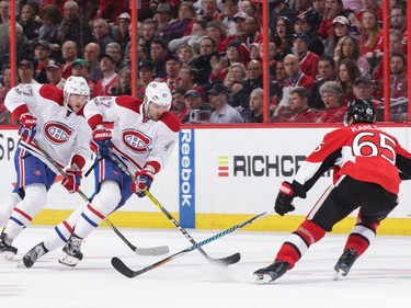 Erik Karlsson #65 of the Ottawa Senators defends against Alexander Radulov #47 and Alex Galchenyuk #27 of the Montreal Canadiens in the third period at Canadian Tire Centre on March 18, 2017 in Ottawa.
