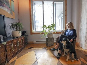 Kate Greaves in the living room of her St-Henri apartment with her dog Anouk in Montreal on Wednesday Feb. 22, 2017. She says that's her favourite spot in the apartment. The landlord created the interesting wood floor using plywood with panels routed out of them and then stained different tones.