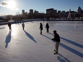 Skaters watch the setting sun over downtown Montreal on Monday January 14, 2013, while at the rink in the Old Port.