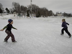 Despite warm weather a couple of kids take advantage of the outdoor rink at Bedard Park in St-Lazare on Jan. 9, 2016.