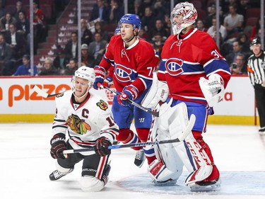 Chicago Blackhawks Jonathan Toews winces after being knocked to the ice by Montreal Canadiens Alexei Emelin in front of goalie Carey Price during second period of National Hockey League game in Montreal Tuesday March 14, 2017.