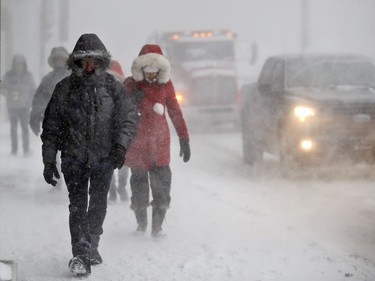 Commuters walk through blowing snow on St. Antoine St. in Montreal, Tuesday March 14, 2017, as a major snow storm started up. By Wednesday morning, more than 35cm of snow had fallen, with more expected through Thursday morning.