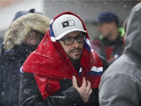 Jean-Philippe Paquette wears a Montreal Canadiens jersey as a scarf as he waits to get into the La Cage Brasserie sportive in the Bell Centre prior the Habs game in Montreal Tuesday March 14, 2017. By Wednesday morning, more than 36 cm of snow had fallen. (John Mahoney / MONTREAL GAZETTE)
