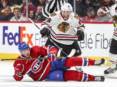 Montreal Canadiens Alex Galchenyuk is knocked down by  Chicago Blackhawks Marcus Kruger during second period of National Hockey League game in Montreal Tuesday March 14, 2017.
