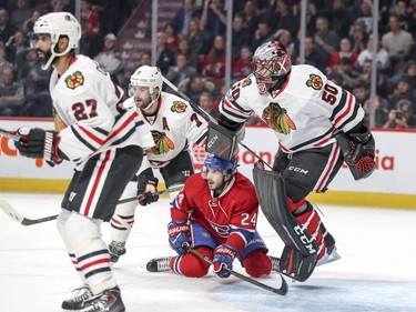 Montreal Canadiens Phillip Danault slides into Chicago Blackhawks goalie Corey Crawford behind Hawks Johnny Oduya, 27, and Brent Seabrook during first period of National Hockey League game in Montreal Tuesday March 14, 2017.