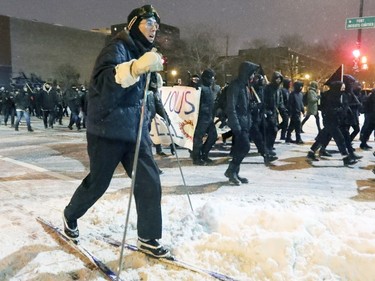 Anti-police brutality demonstrator cross country skis alongside protesters walking from Hochelaga-Maisonneuve to downtown Montreal Wednesday March 15, 2017.