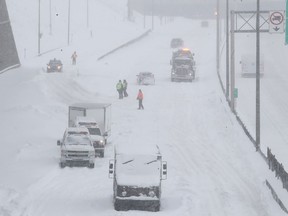 SQ officers and safety crews try to clear up Highway 13 near Côte-de-Liesse Rd. March 15, 2017, following massive snow storm that left many motorists stranded overnight.