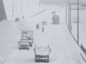 SQ officers and safety crews try to clear up Highway 13 near Côte-de-Liesse Rd. on March 15, 2017, following a snow storm that left many motorists stranded overnight.