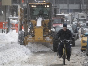 A cyclist makes his way up Drummond St. as Montreal work crews clean snow on March 16, 2017. N.D.G. residents said their snow-clearing operations were going much more slowly.