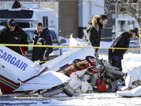 Investigators from Transport Safety Board and Longueuil police inspect the wreckage of a small air plane that crashed in the parking lot of Promenade St-Bruno south of Montreal Friday March 17, 2017 after a mid-air collision with another aircraft that crashed onto the roof of the shopping mall.