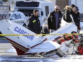 Investigators from Transport Safety Board and Longueuil police inspect the wreckage of a small aircraft that crashed in the parking lot of Promenades St-Bruno south of Montreal Friday March 17, 2017 after a mid-air collision.