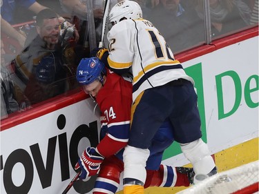 Montreal Canadiens' Alexei Emelin (74) is brought hard into the boards by Nashville Predators' Mike Fisher (12) during second period NHL action in Montreal on Thursday March 2, 2017.