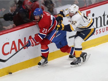 Montreal Canadiens' Dwight King (21) goes for puck with Nashville Predators' Matt Irwin (52) coming in from behind, during first period NHL action in Montreal on Thursday March 2, 2017.