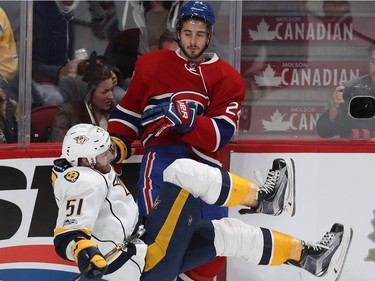 Nashville Predators' Austin Watson (51) is brought down to the ice by Montreal Canadiens' Phillip Danault (24) during second period NHL action in Montreal on Thursday March 2, 2017.