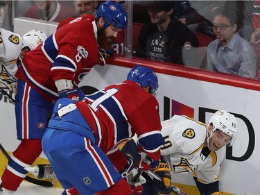 Nashville Predators' Calle Jarnkrok (19) winces as he goes down next to Montreal Canadiens' Jordie Benn (8) and Dwight King (21), during first period NHL action in Montreal on Thursday March 2, 2017.
