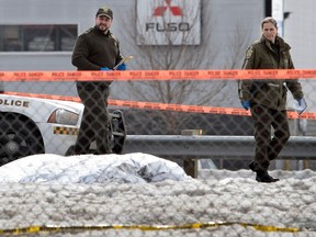 SQ officers are seen near a large bag that was said to contain a body on the side of Highway 13 in Laval on March 21, 2017.