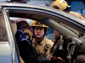 Montreal firefighters tend to a taxi driver who accidentally backed his car through the Delta Hotel doors during a Greenpeace protest outside The National Energy Board meetings in Montreal March 28, 2017.