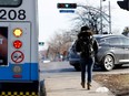 A pedestrian nears the crosswalk at the corner of Brunswick and St-Jean boulevards as a motorist makes an illegal right turn on March 3.