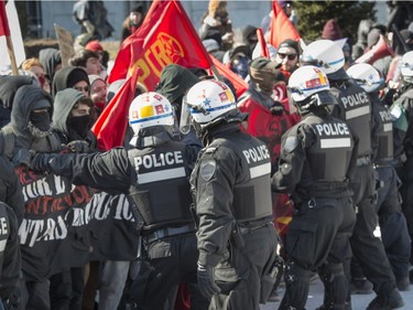 Police try to slow down the march of protesters as they attempt to follow another group the Canadian Coalition of Concerned Citizens to uphold Canadians' Charter rights, who held a demonstration in front of Montreal city hall Saturday, March 4, 2017.