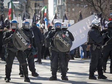 Police watch to keep anti-racism protesters from approaching protesters consisting of far-right groups at a demonstration in front of Montreal city hall Saturday, March 4, 2017.