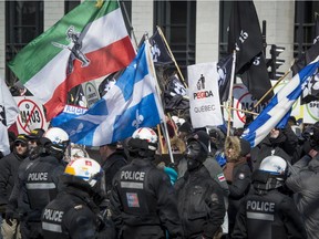 Police watch a group of far-right protesters at a demonstration in front of Montreal city hall on Saturday, March 4, 2017.
