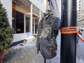 A scorched jacket smoulders on a mannequin outside the Giorgio menswear store on Peel St. in Montreal Wednesday March 8, 2017 after the window was smashed and what appeared to be an incendiary device tossed inside. (John Mahoney / MONTREAL GAZETTE)