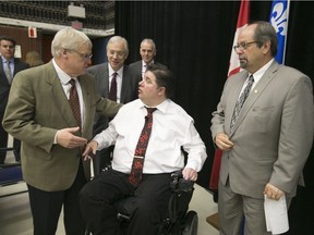 Canada’s Minister of Veterans Affairs Kent Hehr (centre) chats with Quebec Health Minister Gaétan Barrette (left), as Geoffrey Kelley, MNA for Jacques-Cartier looks on following a press conference at the Ste.-Anne's Hospital in Ste-Anne-de-Bellevue on May 30, 2016, to announce the transfer of the hospital from federal control to Quebec's health and social services network. The hospital will now house non-veteran patients as well as veterans, and will become a long-term care centre.