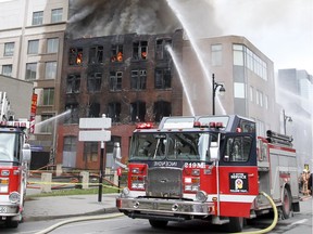Firefighters battle a fire in a building at the corner of St. Laurent and Viger Sts. in Montreal Thursday November 17, 2016.