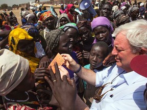 UN humanitarian chief Stephen O'Brien checks a beneficiary's ration card for a food distribution on March 4, 2017, in Ganyiel, Panyijiar county, Unity state, in South Sudan.
