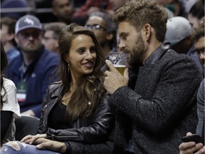 The Bachelor Nick Viall and fiancée Vanessa Grimaldi watch during the first half of an NBA game between the Milwaukee Bucks and the Atlanta Hawks Friday, March 24, 2017, in Milwaukee.