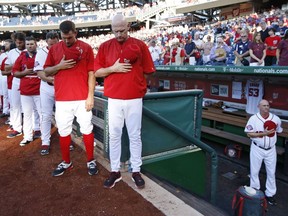 The Washington Nationals pause for a moment of silence for Kimberly Knorr, the late wife of Washington Nationals bench coach Randy Knorr, whose No. 53 jersey hangs in the dugout, before a baseball game against the Atlanta Braves at Nationals Park, Wednesday, June 24, 2015, in Washington.