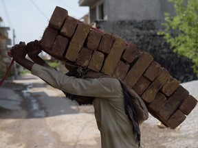 Photo of the day: A Pakistani labourer carries bricks at a construction site in a residential area of Islamabad, March 29, 2017.