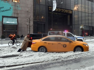 Storms are the great equalizer: In front of Trump Tower in New York City on Tuesday, March 14, 2017, a passenger pushes a cab through some of the snow dumped by Winter Storm Stella. New York City escaped the worst of it, but this guy probably didn't feel too fortunate.