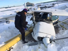 Transportation Safety Board of Canada investigator Isabelle Langevin examines a plane that landed on the roof of Promenades St-Bruno after colliding with another plane on March 17, 2017.