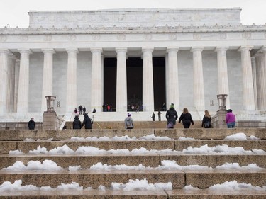 People make there way up the steps of the Lincoln Memorial in Washington DC on March 14, 2017. Winter Storm Stella dumped sleet and snow across the northeastern United States on Tuesday but spared New York from the worst after authorities cancelled thousands of flights and shut schools.