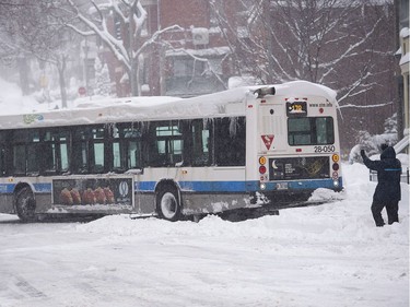 A city bus is helped out of a snow bank after getting stuck following a winter storm in Montreal, Wednesday, March 15, 2017. Graham Hughes / The Canadian Press